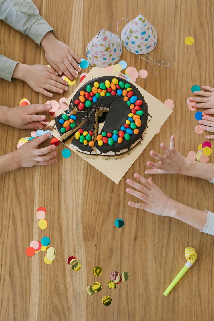 Overhead Shot Of Hands Getting Cake