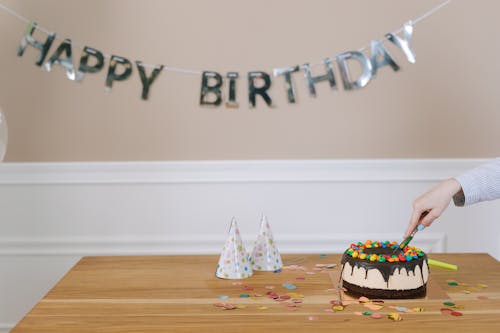 A Person's Hand Slicing a Cake