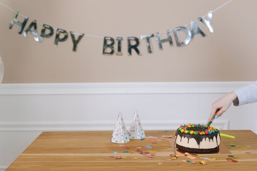 A celebratory birthday cake is sliced, surrounded by party hats and confetti indoors.