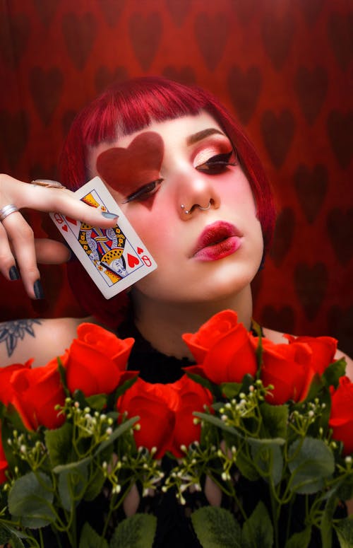 Woman Holding a Playing Card while Looking Afar