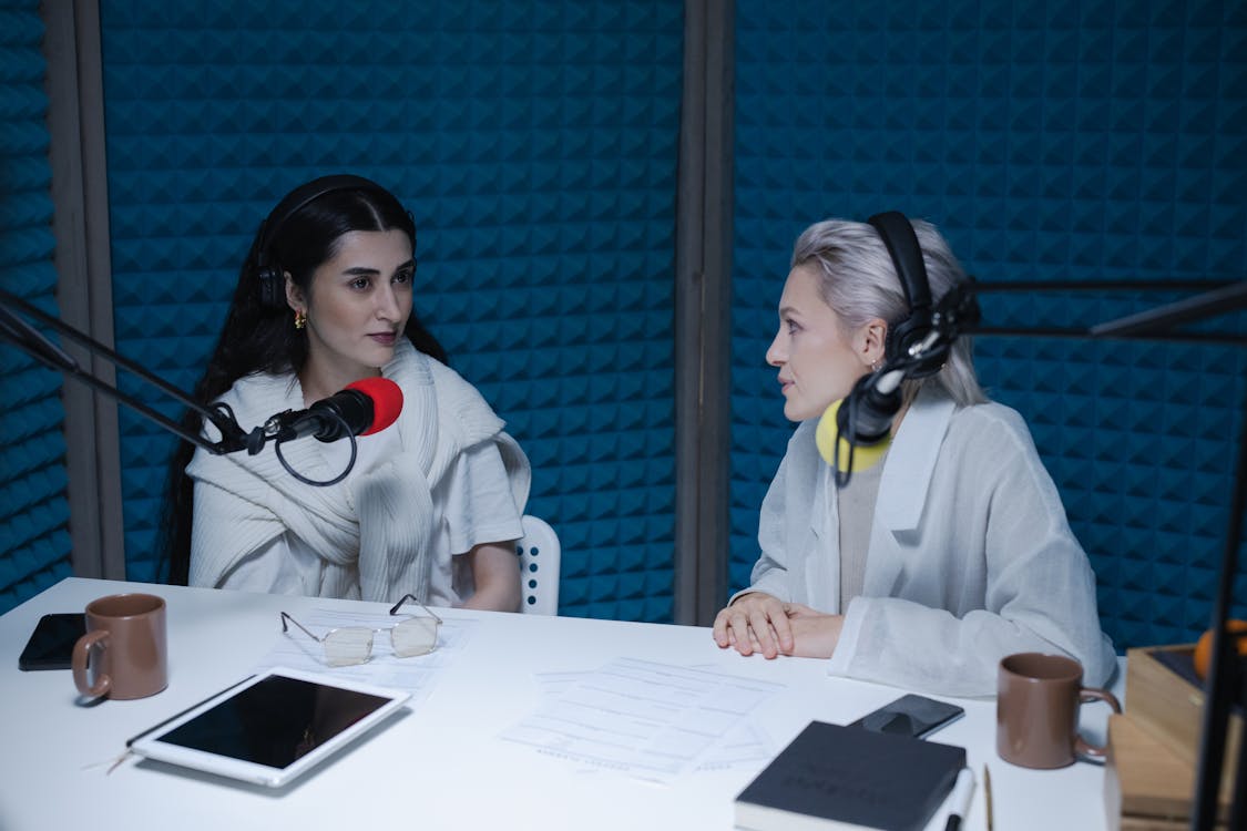 Women Having Conversation while Wearing Headphones