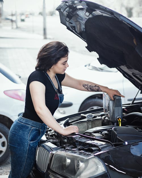 Free A Woman Pouring Engine Oil Stock Photo