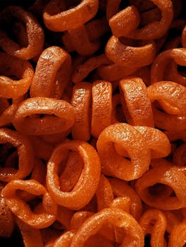 Close-up of vibrant orange cheese rings showcasing their crunchy texture and vibrant color.
