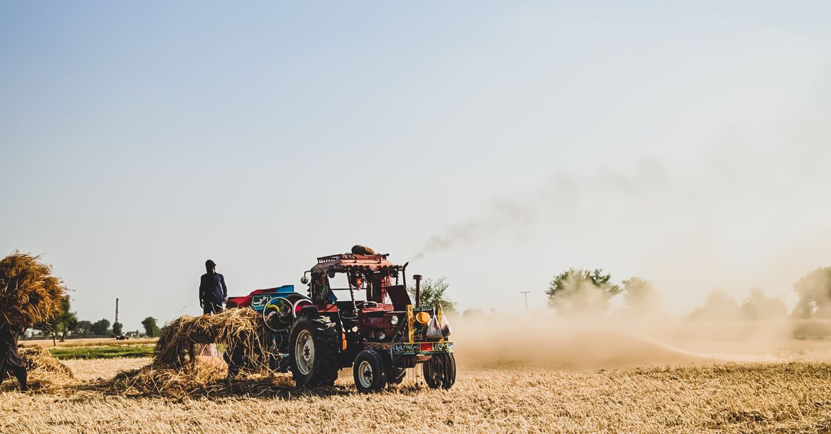 Farm Worker Using Machinery Person Using an Agricultural Machine Tractor on Field · Free Stock Photo
