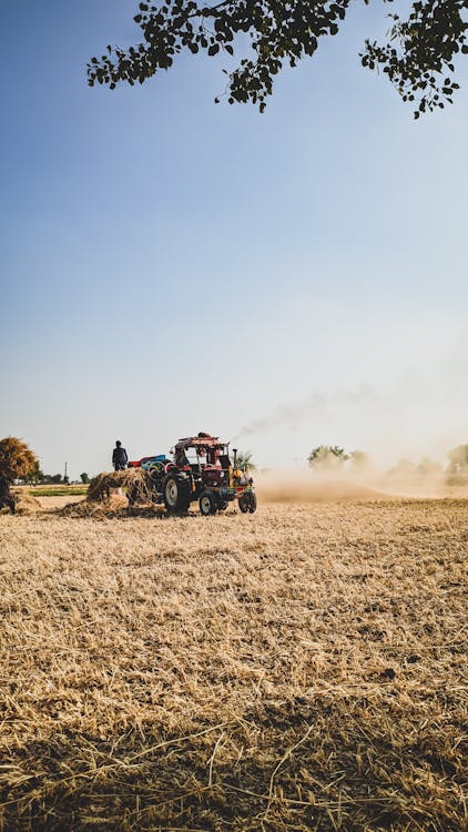 Person Using an Agricultural Machine Tractor on Field