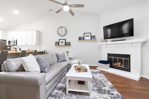 Bright modern living room with fireplace, large TV, and elegant decor.