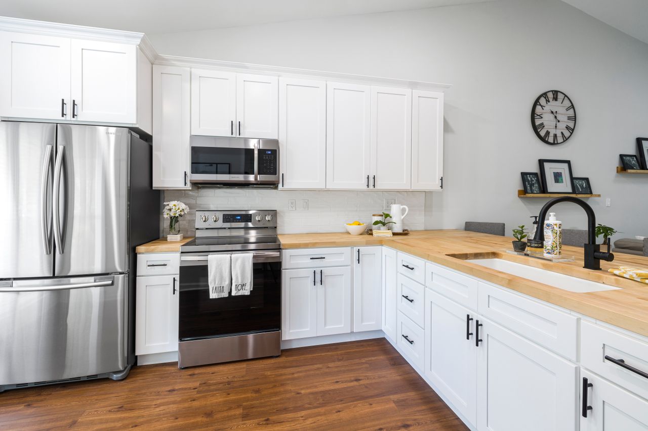 butcher-block-countertops-kitchen Bright white kitchen with warm wooden butcher block countertops