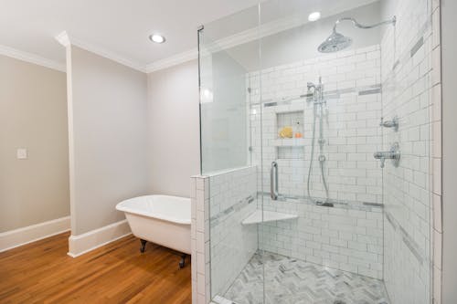 A Shower Area with Glass Door and Freestanding Bathtub