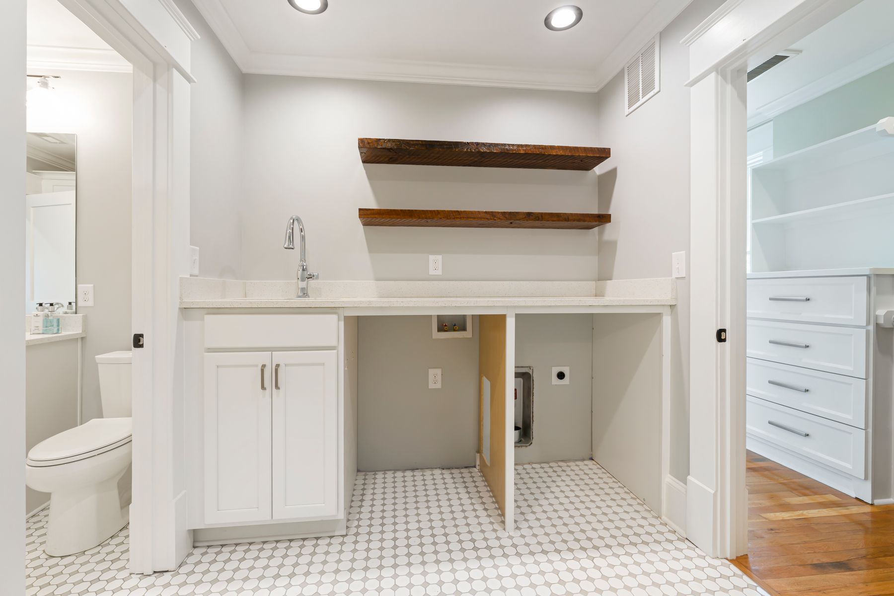 Bathroom with a mix of open shelves and closed cabinetry organized around towels and daily essentials