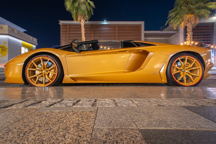 A Yellow Top Down Car Parked On Gray Pavement