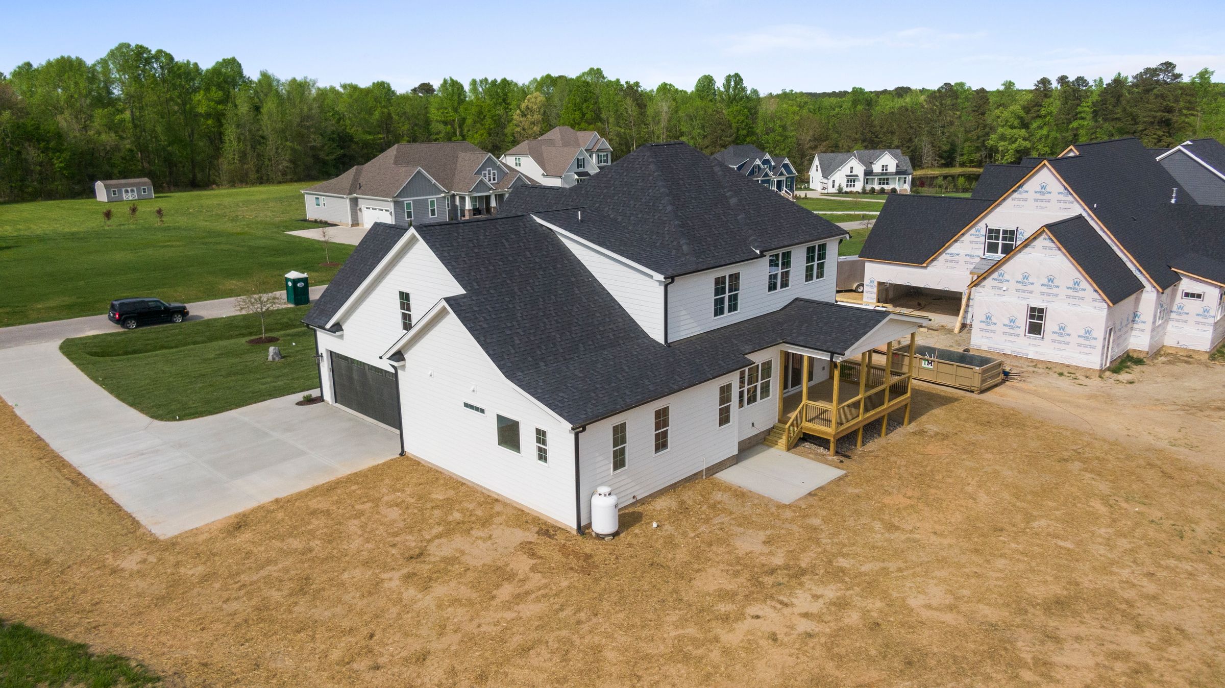 Real aerial photograph of a suburban neighborhood with completed houses and new homes under construction in Youngsville, North Carolina.