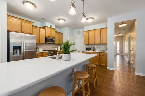 Free Contemporary kitchen with wooden cabinets, white countertop, and stainless steel appliances. Stock Photo