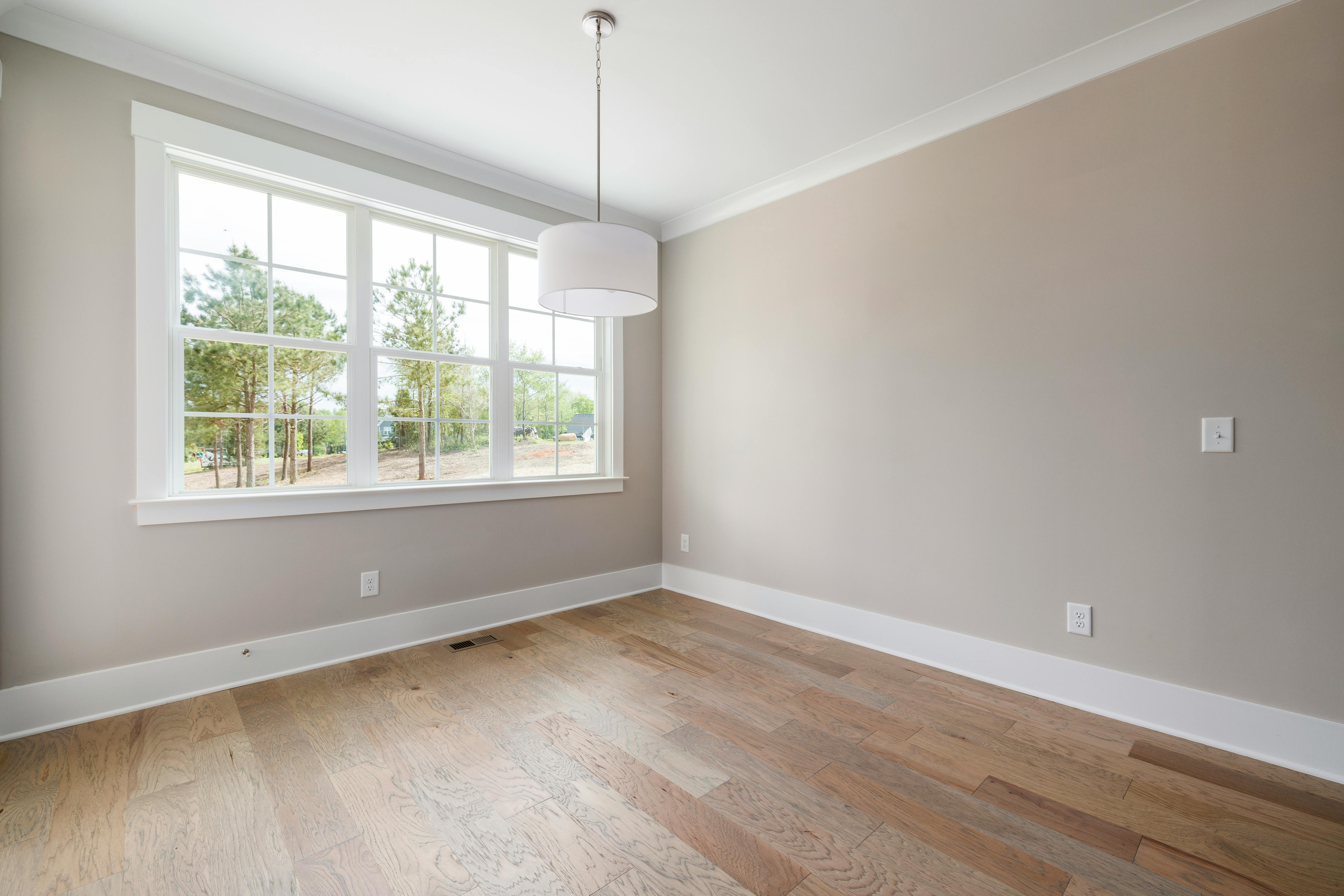 Compact room with greige-toned walls catching natural light from window, showing how paint color affects brightness