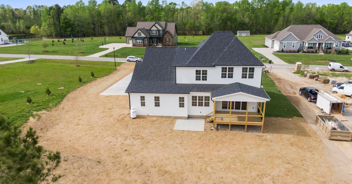 Aerial shot of a suburban home under construction in Youngsville, NC with surrounding greenery.
