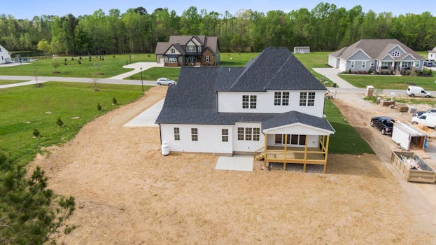 Aerial shot of a suburban home under construction in Youngsville, NC with surrounding greenery.