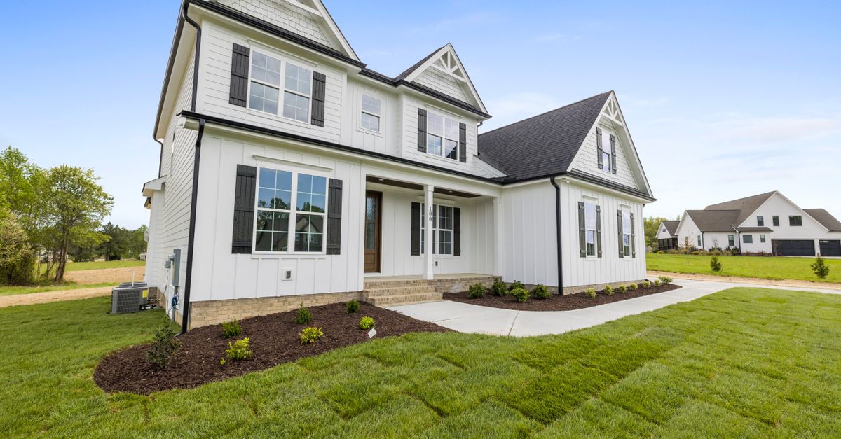 Charming white two-story house with green lawn, showcasing modern architecture and spacious design.