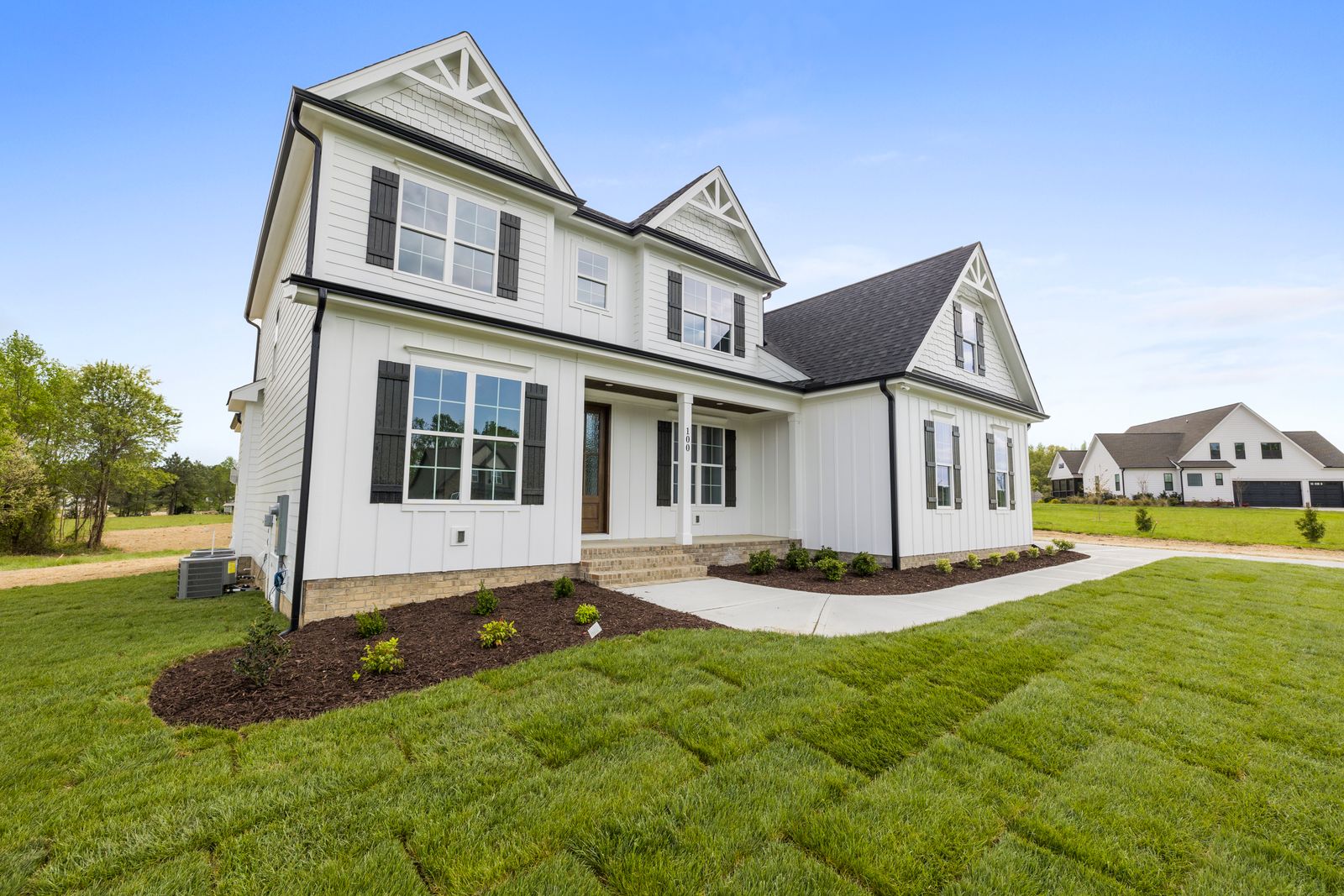 Two-story modern farmhouse-style home with white board-and-batten siding, black shutters, a covered porch, and a manicured lawn, Ashwood Park, Naperville IL