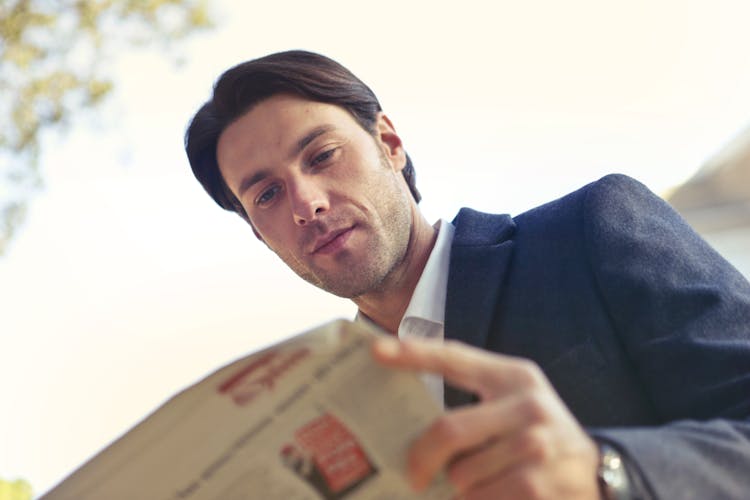 Low Angle Shot Of Man Reading Newspaper