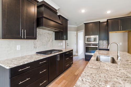 Free Contemporary kitchen featuring dark cabinetry, granite countertops, and stainless steel appliances. Stock Photo