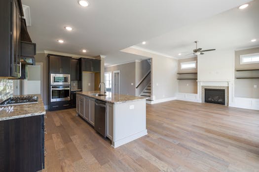Open concept kitchen and living room with modern design and wooden flooring.
