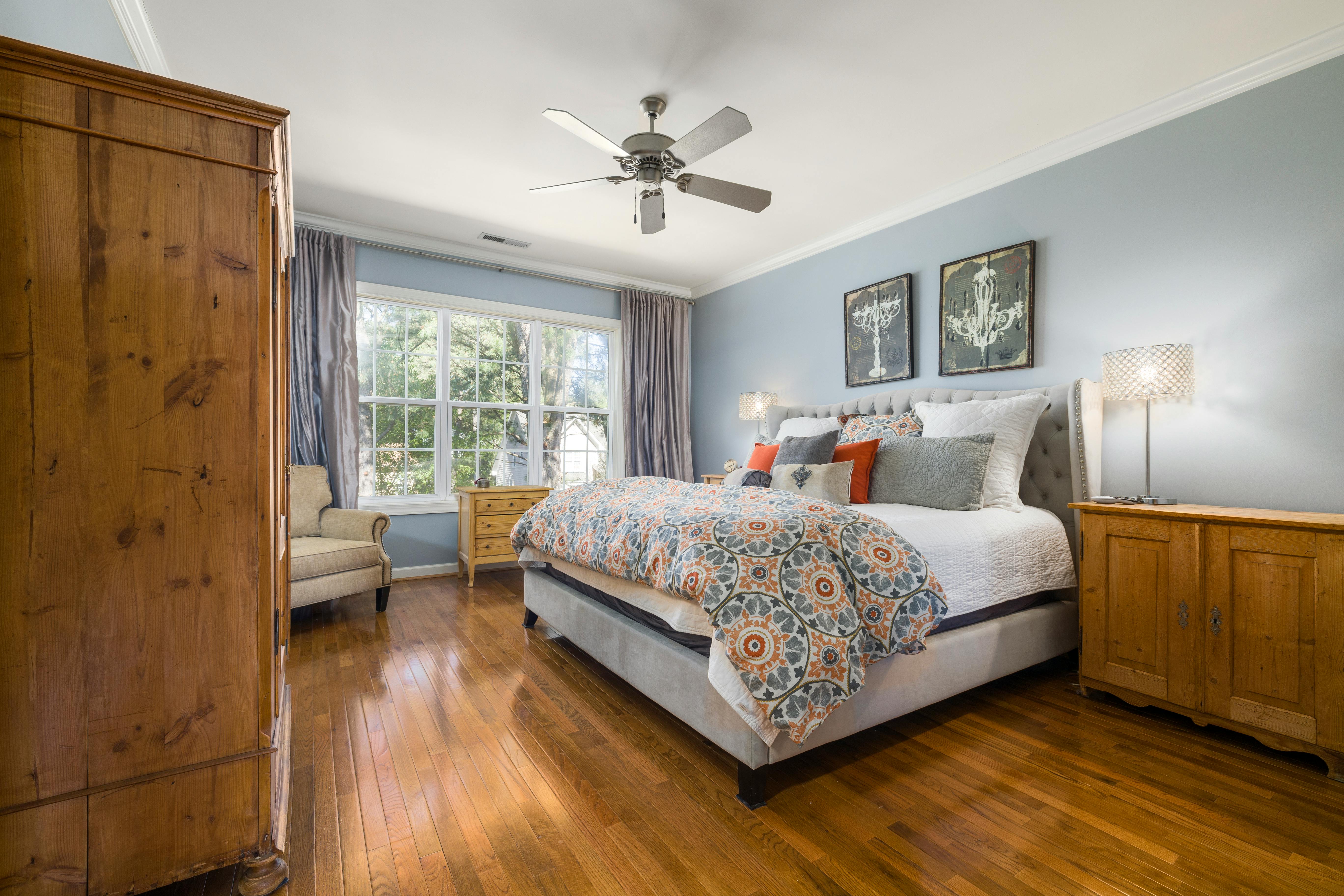 Bedroom interior showing layered textiles including bedding, throw blanket, and pillows