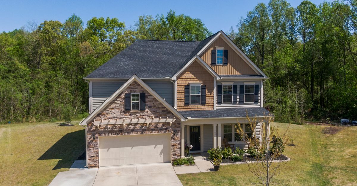 Aerial view of a modern suburban house in Fuquay-Varina surrounded by lush greenery.