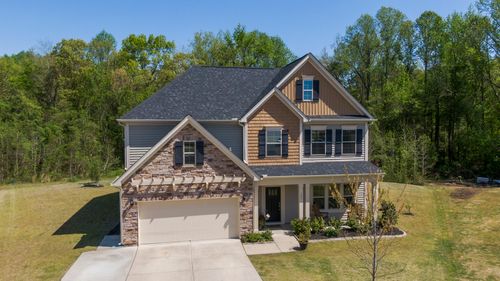 Free Aerial view of a modern suburban house in Fuquay-Varina surrounded by lush greenery. Stock Photo