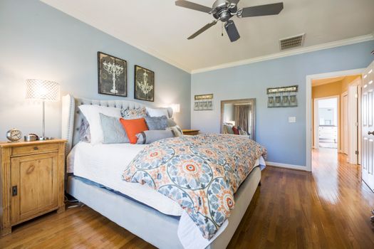 Inviting bedroom with blue walls, stylish decor, and comfortable bedding offering a relaxing ambiance.
