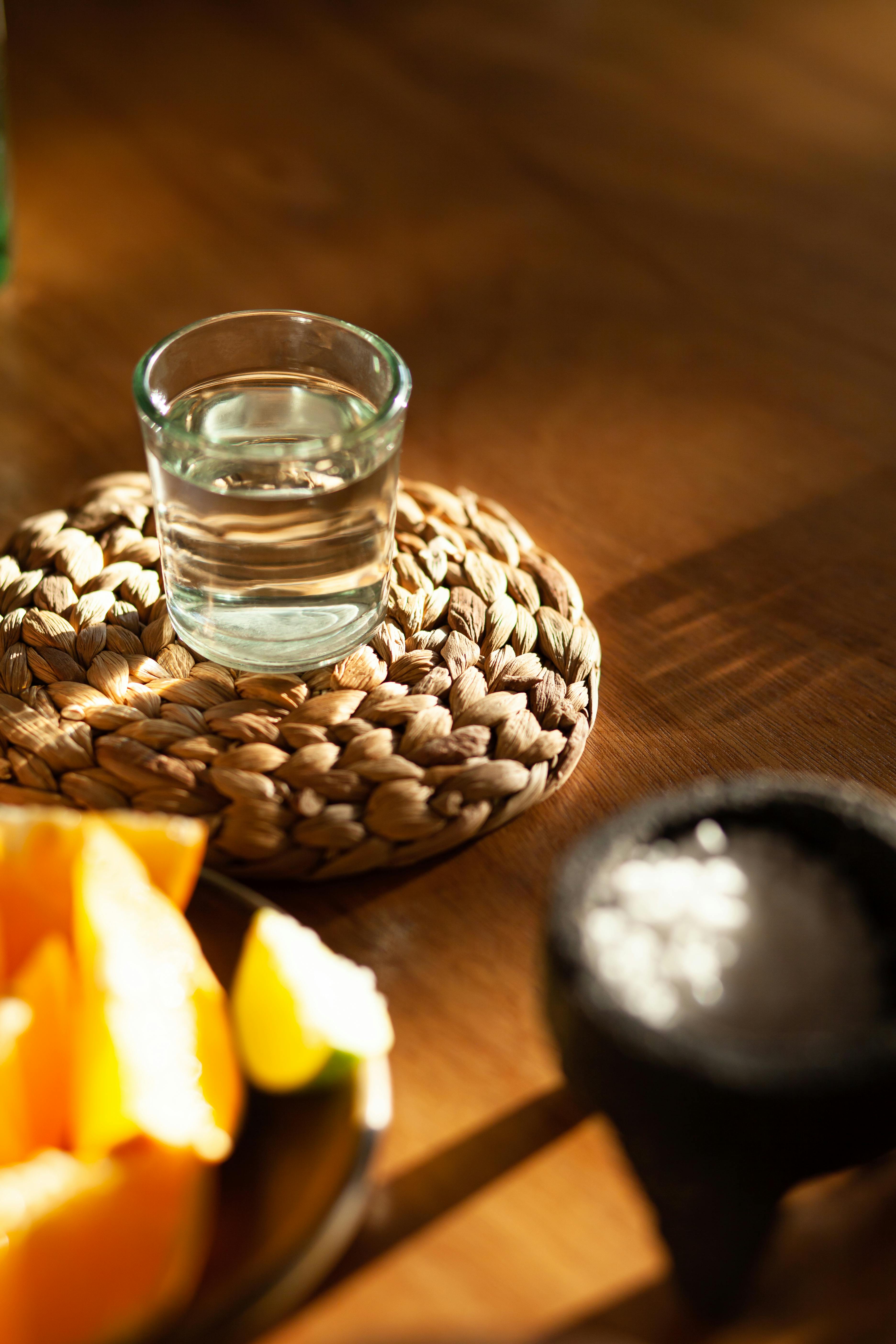 a shot of tequila on woven coaster