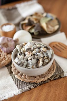 A bowl of fresh huitlacoche on a rustic table with garlic and onion. Perfect for food photography. - Fotografer Sidoarjo