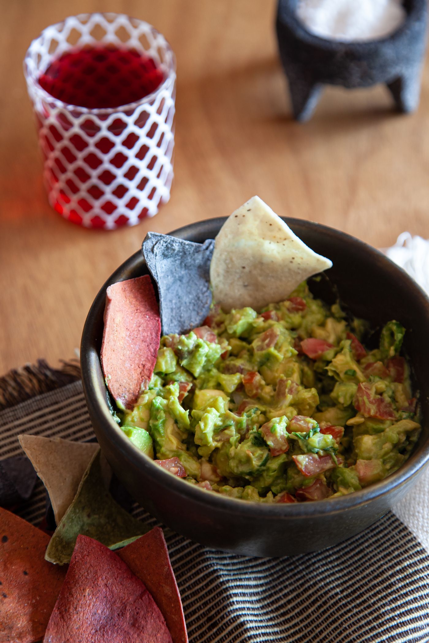 Bowl of guacamole with tortilla chips on a wooden table