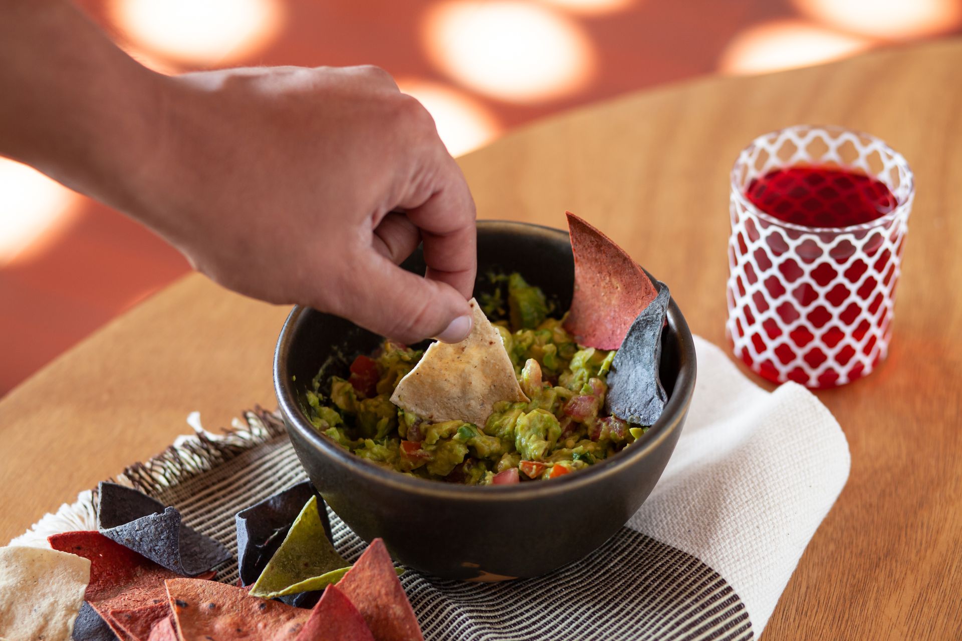 A Person Dipping Chip on Guacamole
