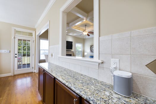 Bright kitchen space featuring granite countertops, coffered ceiling, and contemporary decor.
