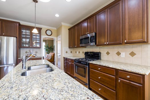 Spacious modern kitchen featuring wooden cabinets, granite countertops, and stainless steel appliances.