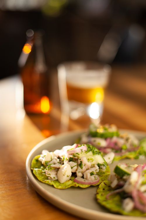 Free Close-up of ceviche tostadas paired with craft beer, ideal for food photography and culinary enthusiasts. Stock Photo