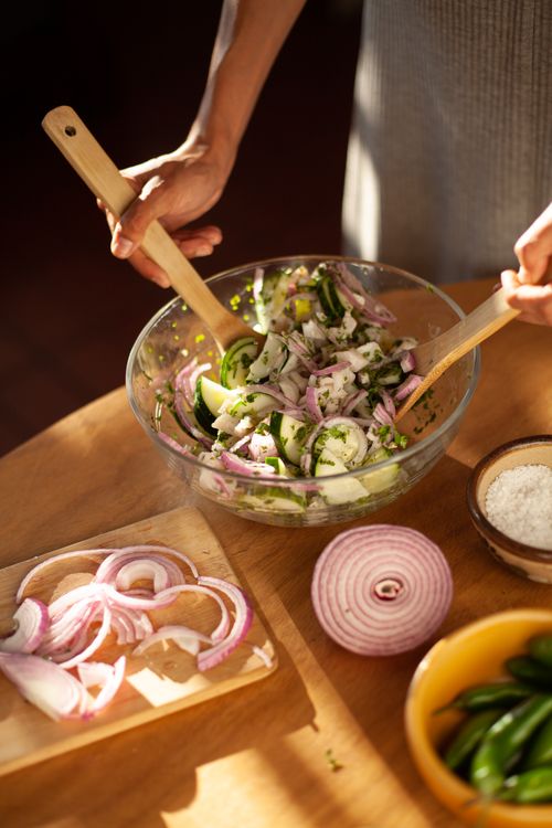 Free Hands mixing fresh vegetable salad with sliced onions and chilies. Perfect for healthy eating inspiration. Stock Photo