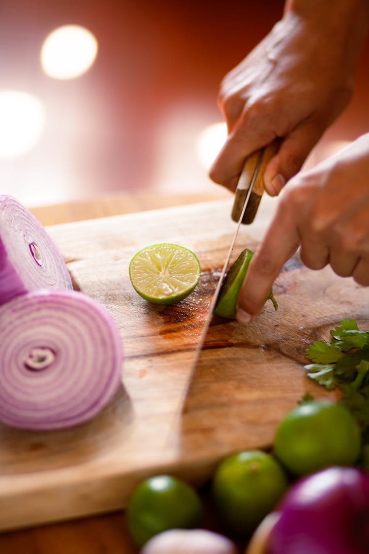 A Person Slicing A Lime