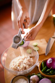 Hands squeezing lime into a bowl of ceviche, showcasing vibrant Mexican ingredients.