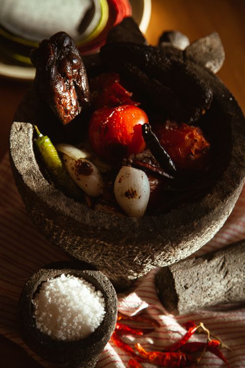 Free Roasted vegetables and spices in a stone mortar with pestle. Stock Photo