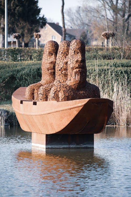 Modern Sculpture with Heads in Boat on Water