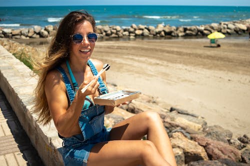 A Woman with Sunglasses Using Chopsticks