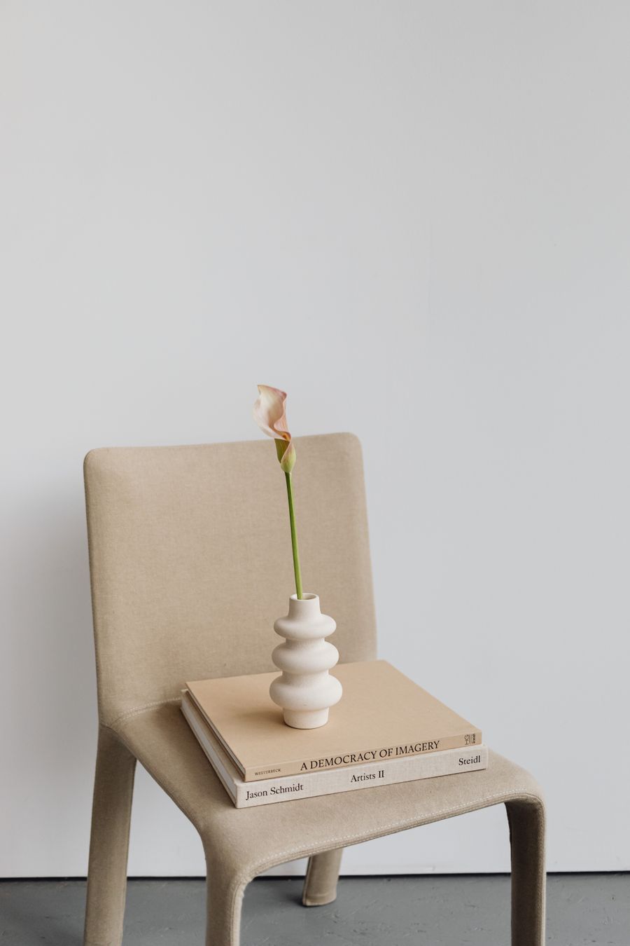 Calla lelie in een vaas op een stoel met boeken