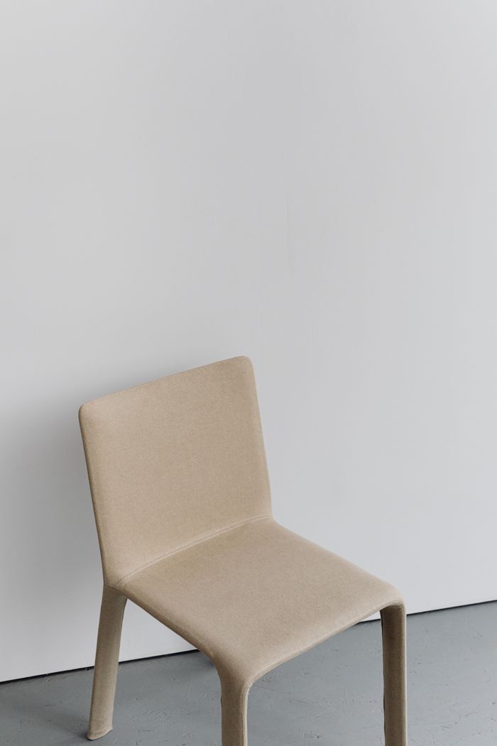 Minimalist beige chair against a white wall — photo by Kaboompics on Pexels