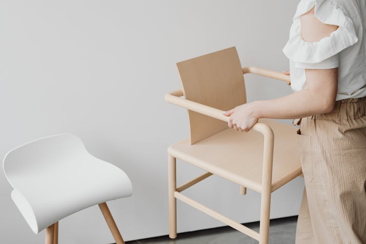 Woman Picking Up Minimalist Chair