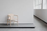 A minimalist wooden chair in a contemporary art studio setting, showcasing modern design.