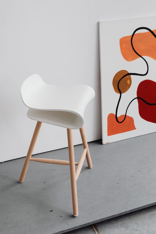 Free A minimalist white chair beside a bold abstract painting in a modern interior setting. Stock Photo