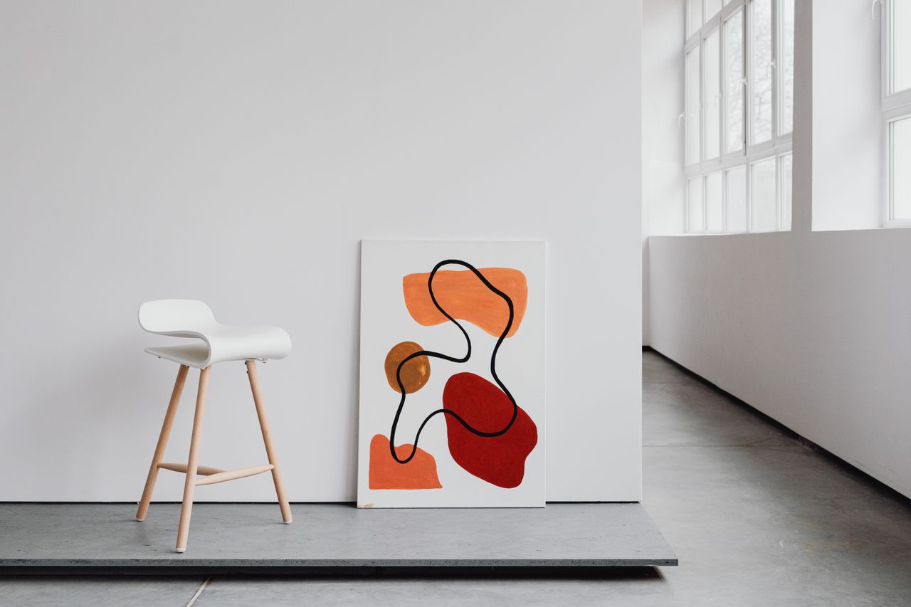 contemporary minimalist art canvas and sleek white chair in a bright m
