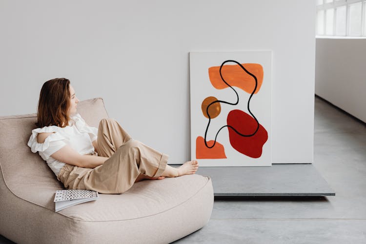 A Woman Looking At An Abstract Painting