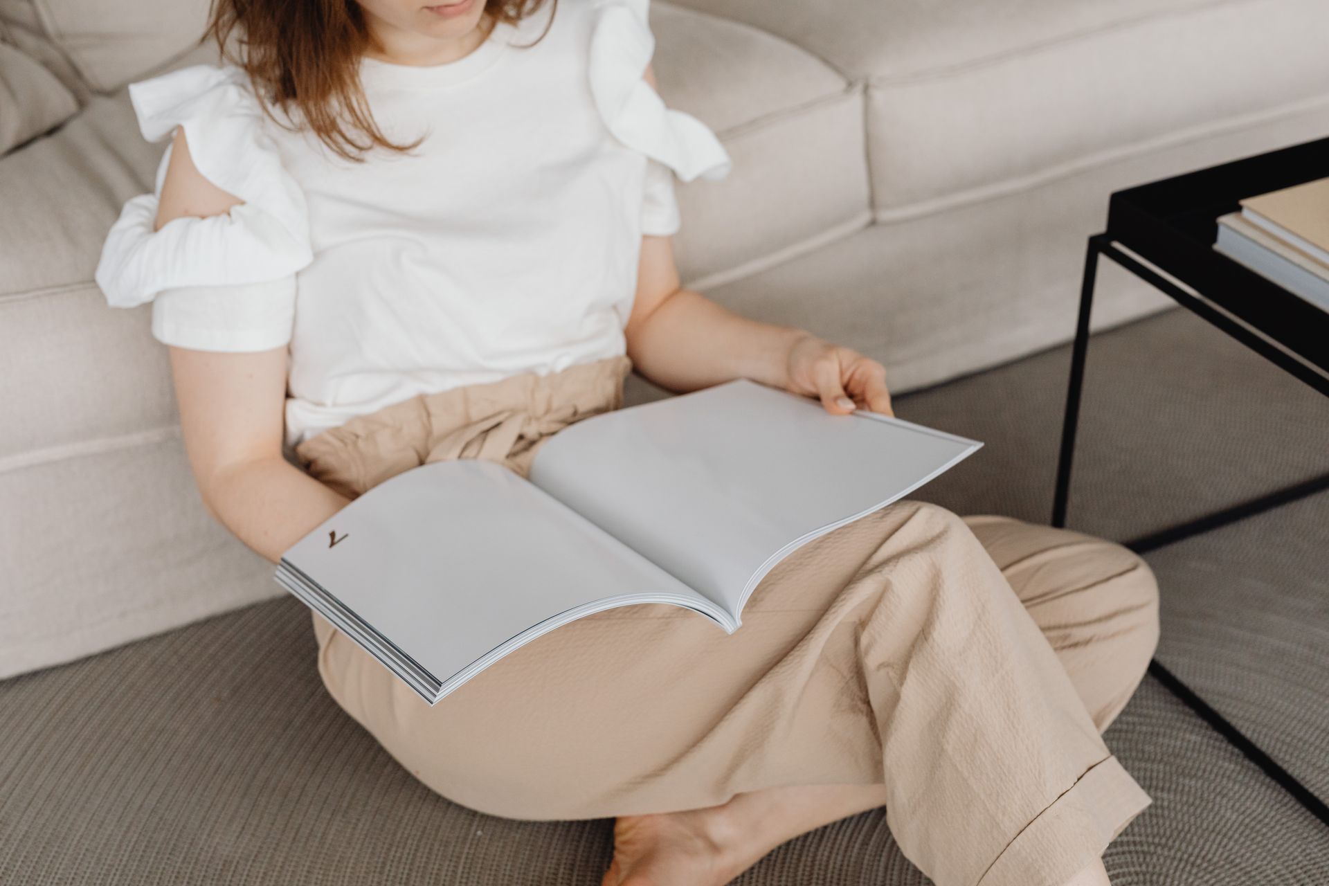 A Woman Looking at Blank pages of a Magazine