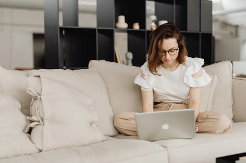 A Woman using Laptop Sitting on the Sofa